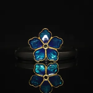 Detail shot of blue five-petal flower alloy DIY jewelry accessory with enamel finish.