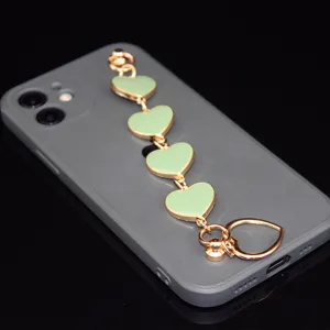 Detail view of green heart alloy phone chain strap accessory, elegant DIY decoration item.