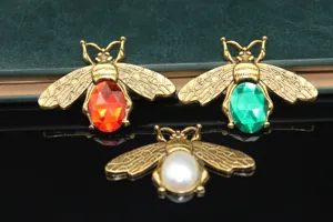 Detailed shot of vintage gold bee rhinestone charms, perfect for DIY phone case and jewelry making.