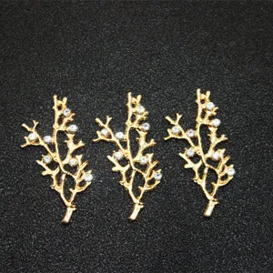 Detail shot of three gold alloy branch jewelry accessories embedded with sparkling rhinestones.