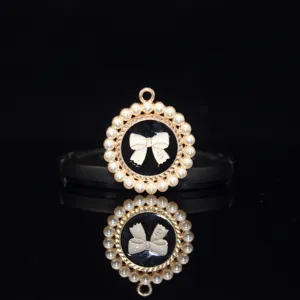 Detail view of alloy pearl bow pendant with oil-drop craft for stylish DIY hair accessories.