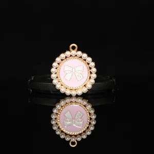 Close-up detail of the pink enamel bow pearl round pendant DIY alloy hair accessory.