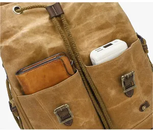 Vintage canvas backpack detail showing front storage pockets and durable leather straps.