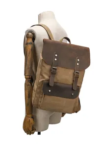 Vintage canvas backpack detail showing retro leather flap and sturdy metal buckles.