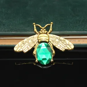 Close-up of vintage gold bee alloy charm with green gemstone, ideal for DIY phone case decor.