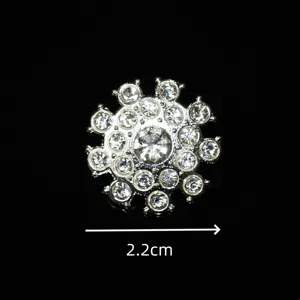 Primo piano del dettaglio del bottone in metallo con strass scintillanti, design floreale.