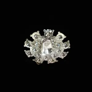 Dettaglio bottone a gambo in metallo argentato, design complesso a punte per cappotti.