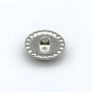 Detailansicht eines silbernen Metall-Stielknopfes mit gezacktem Randdesign für Kleidung.