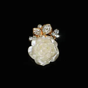 Detailed close-up of a delicate white carved rose alloy accessory adorned with sparkling rhinestones.