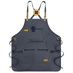 Heavy duty canvas tool apron with cross back leather straps and multiple pockets for garden and work.