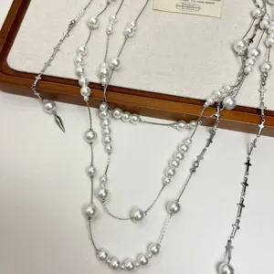 Multi-layer pearl necklace with silver cross chains and dagger pendant, chic vintage sweater chain.