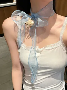 Close up of a blue organza ribbon choker necklace with floral pendant and pearls for women.