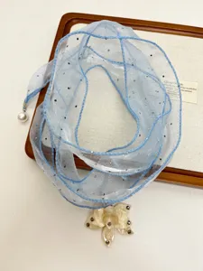 Blue sheer ribbon choker necklace detail with sparkle rhinestones, pearl and floral pendant.