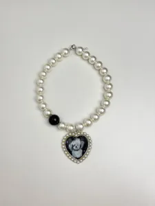 Detailaufnahme der stilvollen Perlenkette mit Hund Herzanhänger und schwarzer Perle.