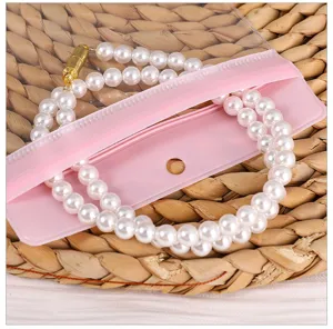Primer plano detallado de joyas de perlas falsas con cierre en bolsa transparente.