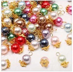 Closeup of colorful glass imitation pearl pendant beads with gold caps for DIY handmade jewelry.