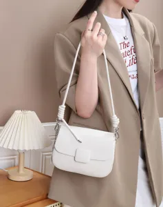 White leather shoulder bag with knot strap detail, premium cowhide design for women.
