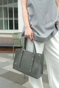 Grey genuine leather tote bag with double strap design and metal buckles for women.