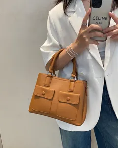 Stylish brown leather tote handbag with top handles and front pockets for daily commute.