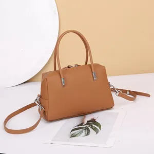 Brown leather Boston handbag with top handles and shoulder strap for daily women fashion.