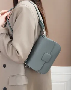 Detailed view of genuine leather shoulder bag showing fine texture, hardware and knot strap.