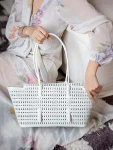 Vue detaillee du sac cabotin en cuir perfore blanc avec anses pour femmes au quotidien.