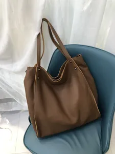 Vista dettagliata della borsa in vera pelle marrone, grande capacità e consistenza morbida.