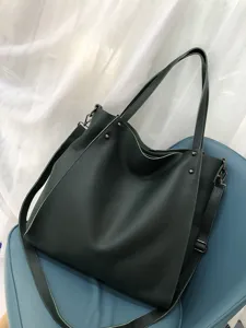 Vista dettagliata di una borsa shopper in vera pelle verde scuro, grande borsa a spalla.