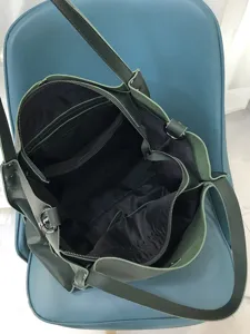 Dettaglio interno borsa a tracolla in vera pelle verde scuro, grande capacità capiente.