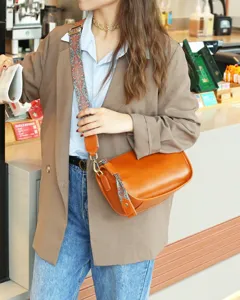 Detail view of vintage genuine leather pillow shoulder bag with wide strap in warm brown tone.