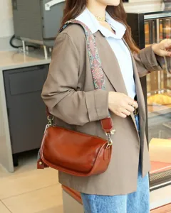 Vintage genuine leather pillow shoulder bag with wide patterned strap for women daily commuting.