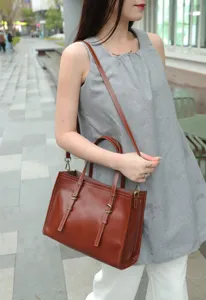 Vintage leather tote bag detail showing genuine leather texture and metal hardware.