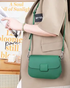 Close-up detail of green leather shoulder bag, premium textured flap crossbody purse.