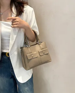 Genuine leather handbag detail view, casual tote bag with double front pockets and sturdy top handles.