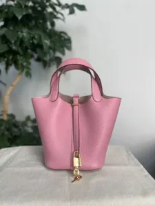 Sac à main seau en cuir rose avec cadenas, sac cabas pour femme au design classique chic.