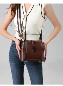 Nahaufnahme Detail der braunen Retro Leder Umhängetasche mit breitem Riemen Metallschloss.