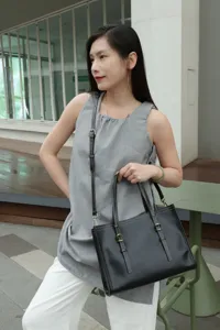 Black leather tote bag for women, retro casual shoulder bag with dual handles and metal buckles.