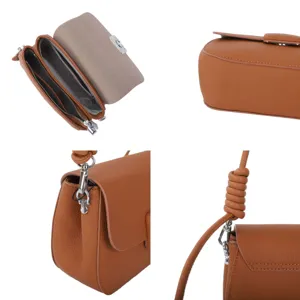 Leather crossbody bag details showing brown Togo texture, metal lock and stylish knot strap.