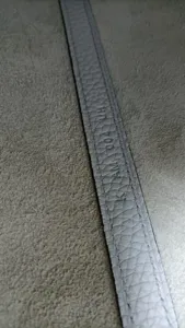 Detailopname van premium rundleer band met handgemaakte waxstiksel en ambachtsman code.