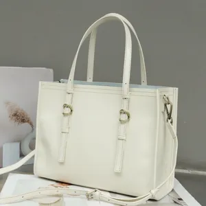 Cream white genuine leather tote bag detail, featuring dual top handles and metal buckle accents.