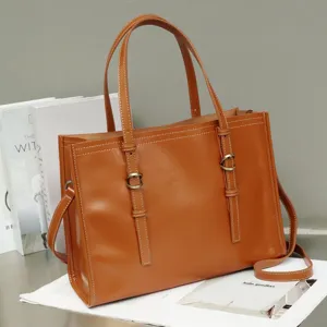Brown leather retro tote bag close-up showing fine stitching and metal buckle details, elegant.