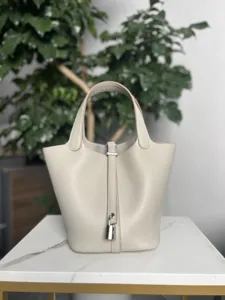 Vue détaillée du sac à main seau en cuir de qualité avec serrure sécurisée et poignée.