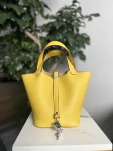 Sac seau jaune en cuir véritable avec cadenas et clés argentés, élégant sac pour femmes.