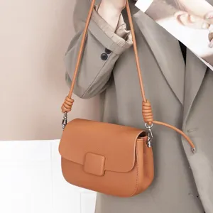Brown leather crossbody bag for women, featuring a chic flap closure and unique knotted shoulder strap.