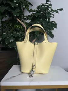 Vue détaillée de sac seau en cuir jaune, cuir haut de gamme avec cadenas et quincaillerie.