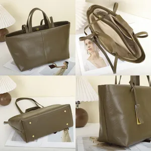 Leather tote bag detail view showing multi-compartment interior and bottom metal feet.