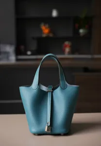 Detail van de blauwe lederen emmertas met premium textuur en een metalen hangslotje.