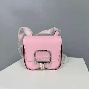 Pink leather saddle bag detail shot, compact crossbody shoulder bag with metal lock.