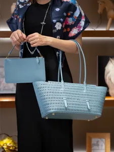 Vue détaillée du sac cabas en cuir perforé bleu clair avec sa pochette assortie et finitions.