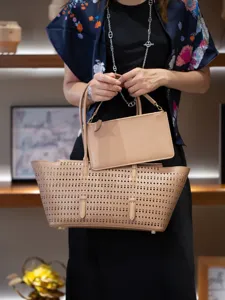 Vue détaillée du sac cabas perforé en cuir beige avec pochette assortie, style élégant.